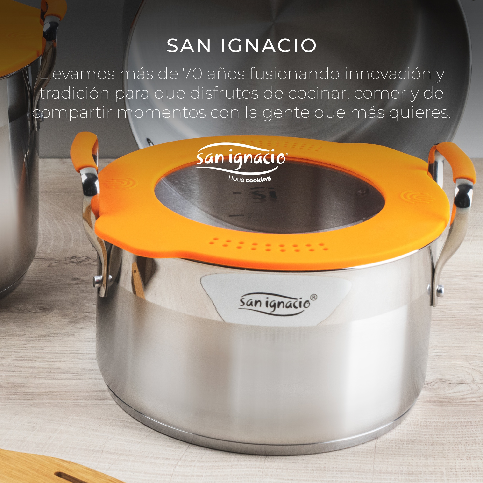 Olla de acero inoxidable con tapa naranja y el logotipo de San Ignacio.