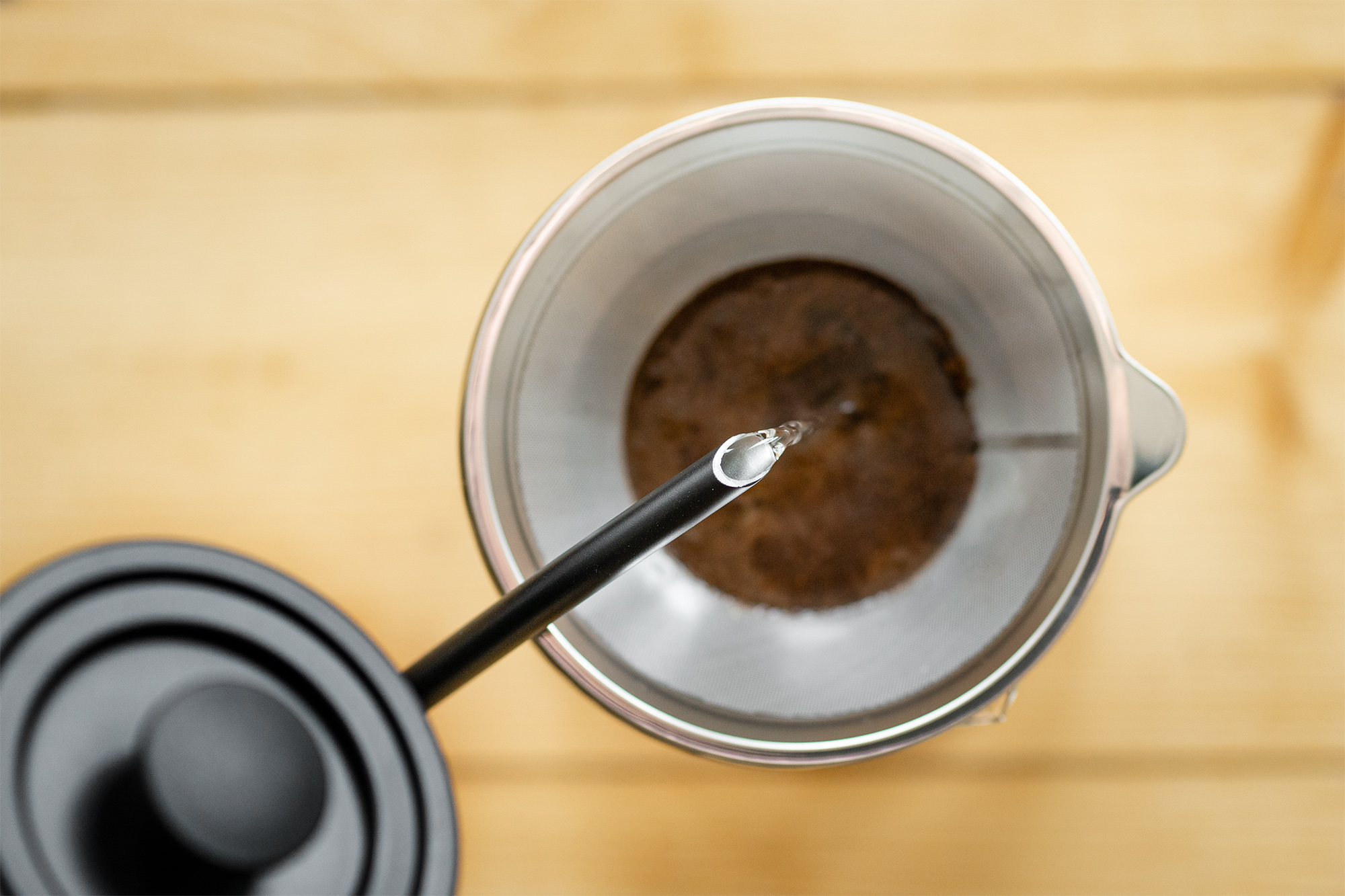 Wasser, das in eine French Press mit Kaffeepulver gegossen wird.