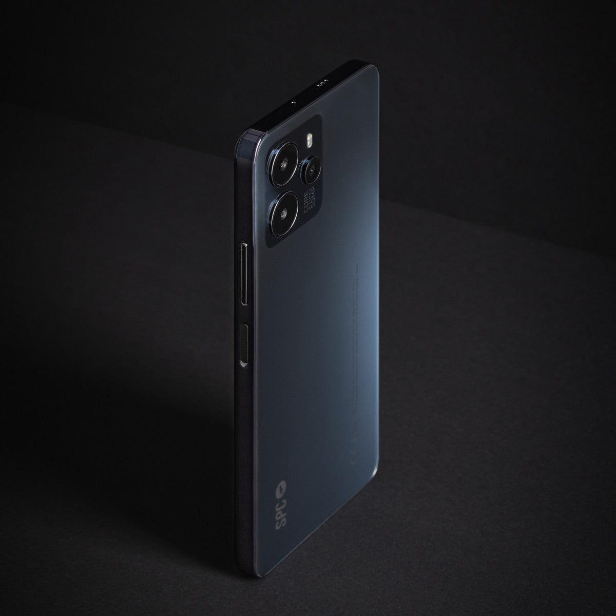 Smartphone nero su superficie scura. Dotato di tripla fotocamera e retro strutturato.