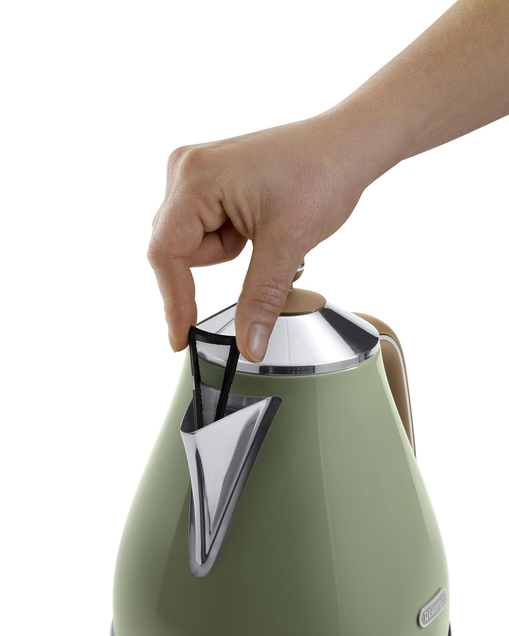 Ręka wyjmuje filtr z zielonego czajnika. Tło jest białe, z czajnikiem.