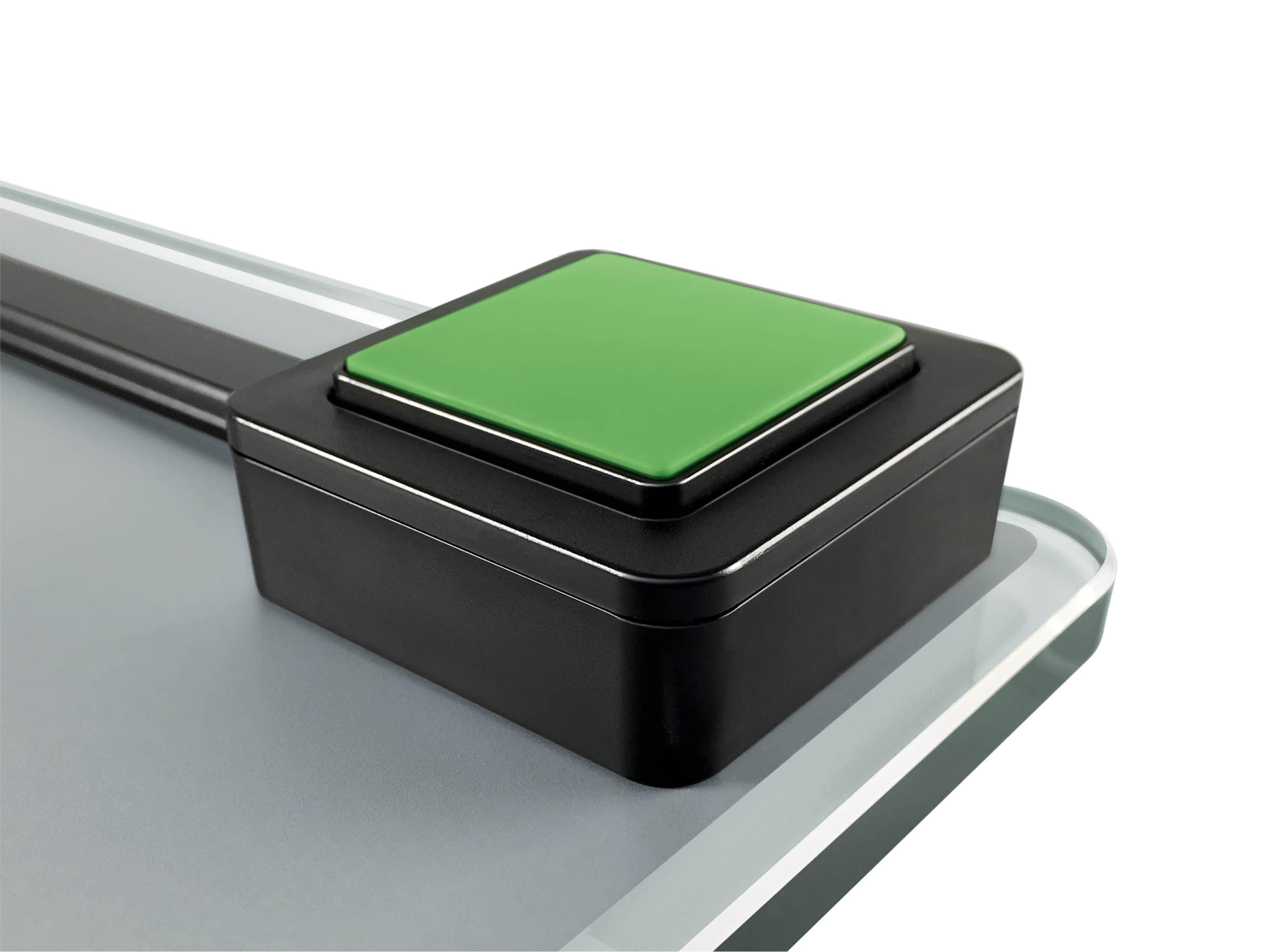 Czarny i zielony kwadratowy przycisk na wadze, zbliżenie.