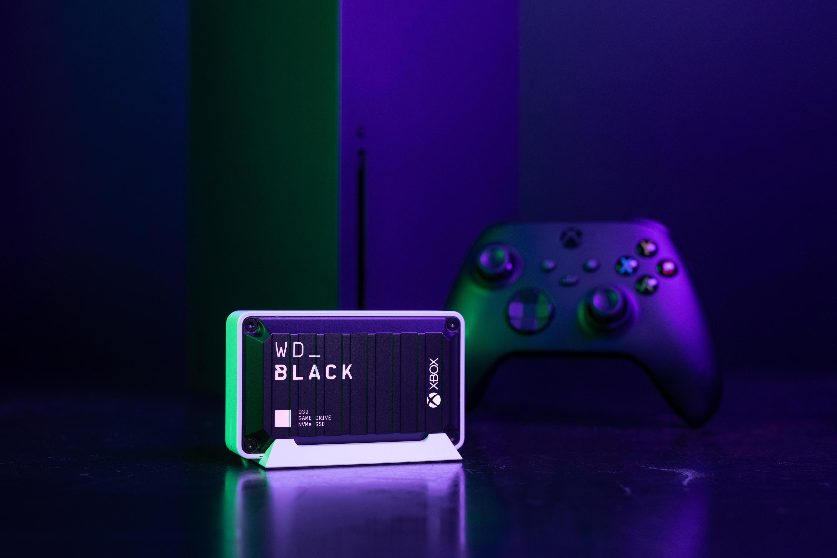 Disco rigido esterno WD_BLACK, console Xbox e controller su una superficie scura.