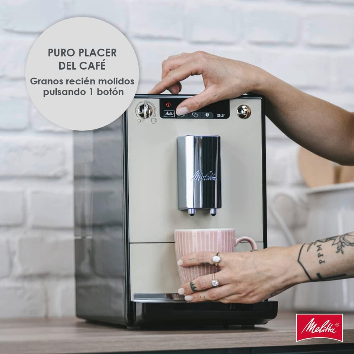 Una persona usando una cafetera Melitta color crema. Una taza rosa está colocada para recibir café.