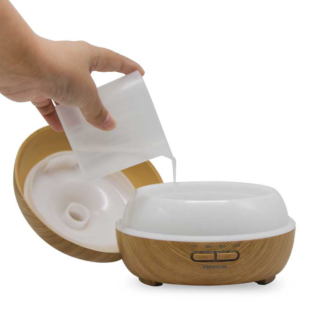 Dłoń wlewa wodę do dyfuzora zapachowego o fakturze drewna, na białym tle.