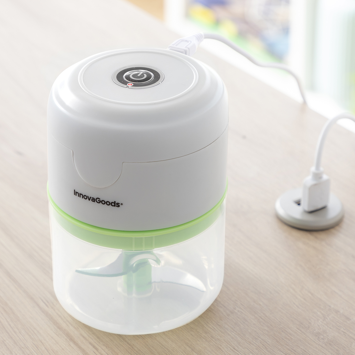 Ein weißer und grüner InnovaGoods Mini-Zerkleinerer mit eingestecktem USB-Kabel.