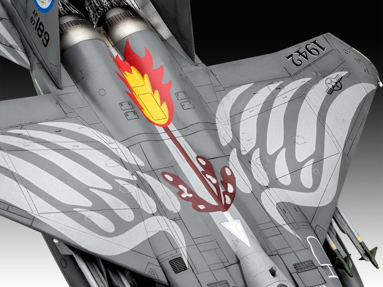 Modellflugzeug, grau mit rotem und gelbem Flammenmuster und weißen Streifen.