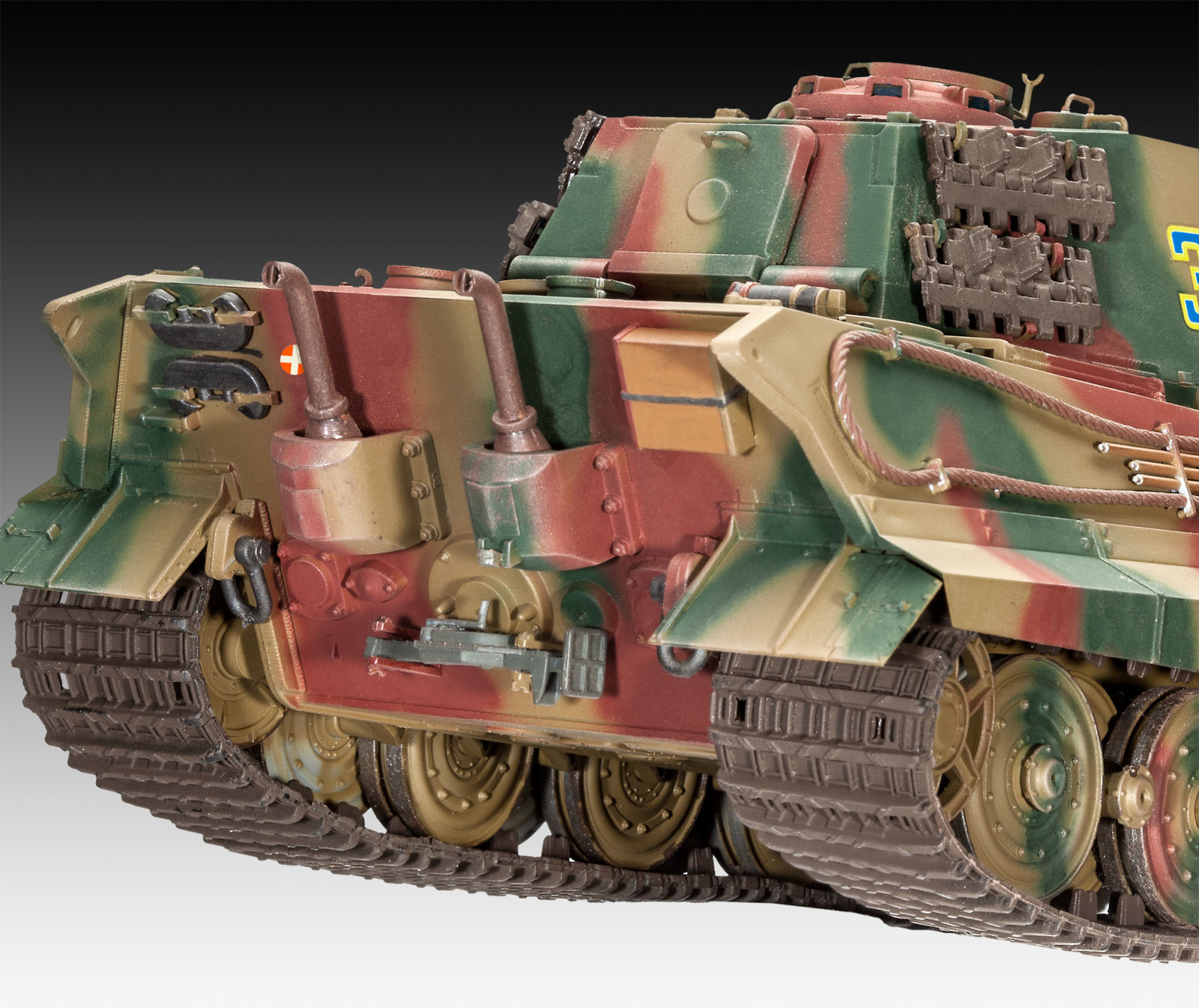 Nahaufnahme eines Modellpanzers, tarnfarben lackiert, zeigt Ketten und Details.
