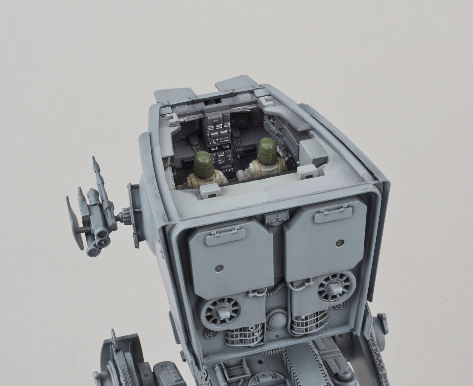 Intérieur d'un modèle AT-ST gris avec deux figurines. La zone du cockpit est visible.