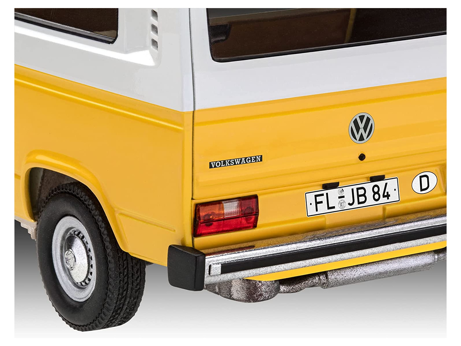 De achterkant van een geel en wit Volkswagen busje model met kenteken FL-JB 84 D.