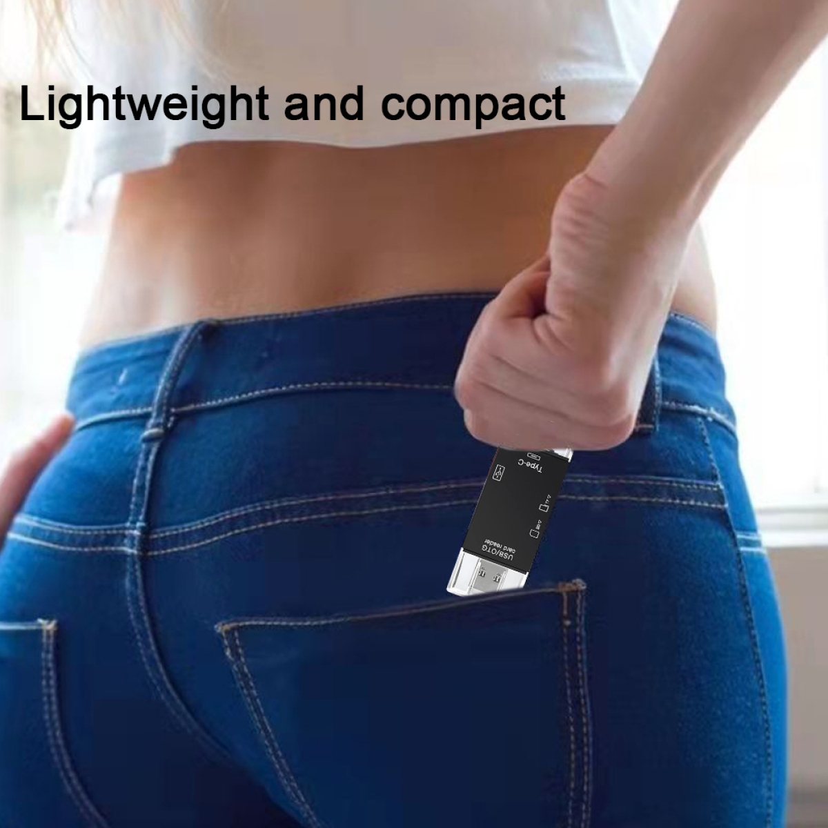 Eine Person steckt einen kleinen schwarzen USB-Stick in die Hosentasche einer Jeans.
