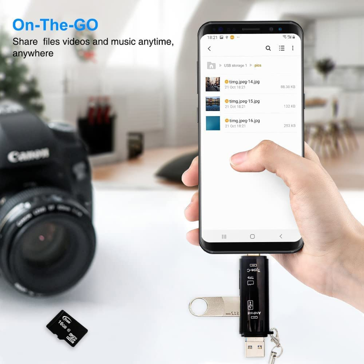 Eine Hand hält ein Telefon, verbunden mit einem USB-Stick mit Bildern. Kamera im Hintergrund.
