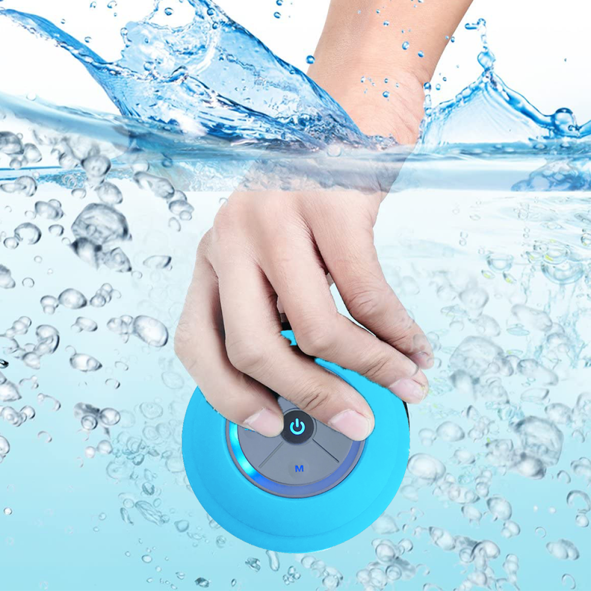 Eine Hand hält einen blauen wasserdichten Lautsprecher im Wasser, umgeben von Blasen. Wasser spritzt.
