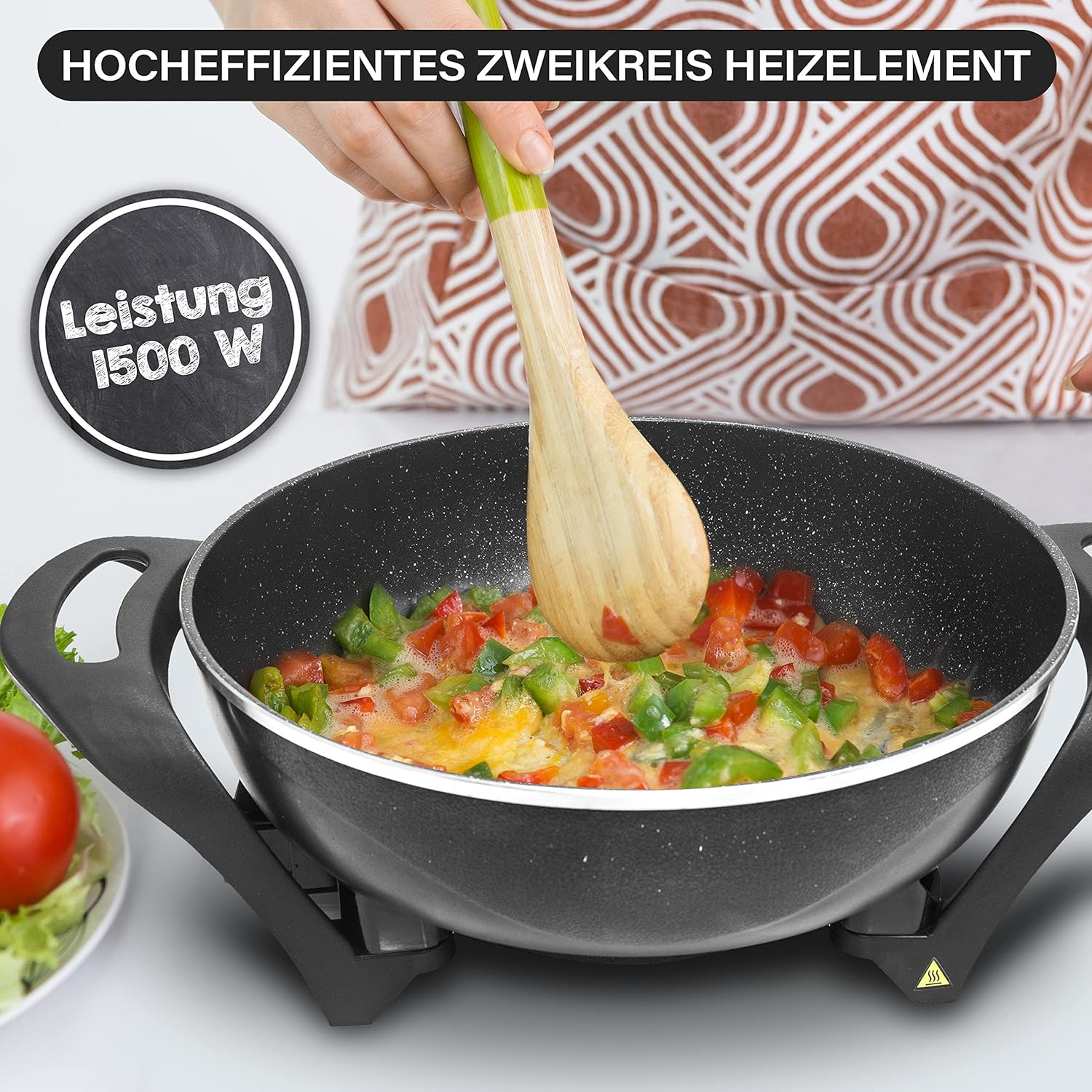 Pfanne mit Gemüse. Eine Hand benutzt einen Holzlöffel. Text: 1500W.