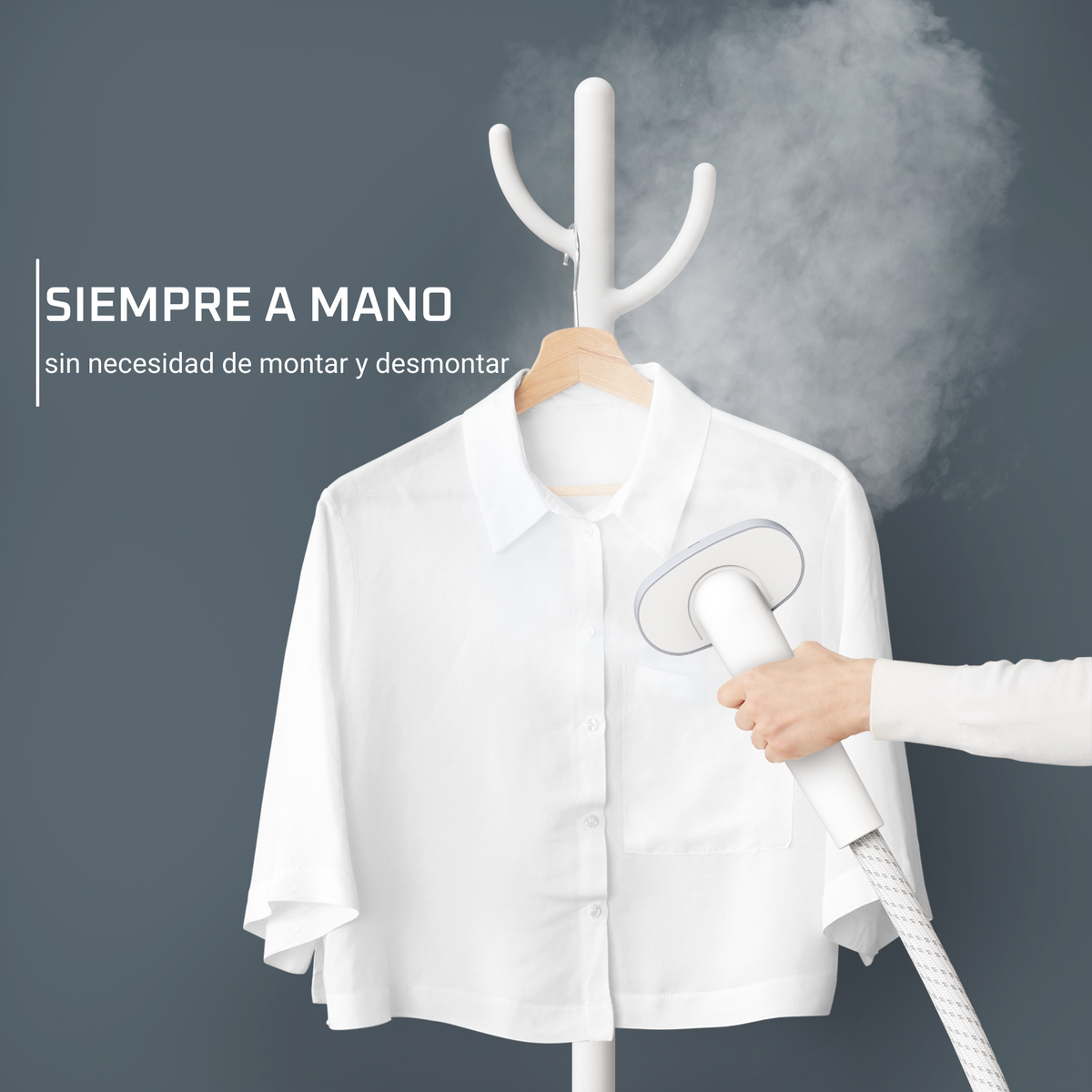 Una camicia bianca appesa a un appendiabiti, stirata a vapore da un vaporizzatore portatile.