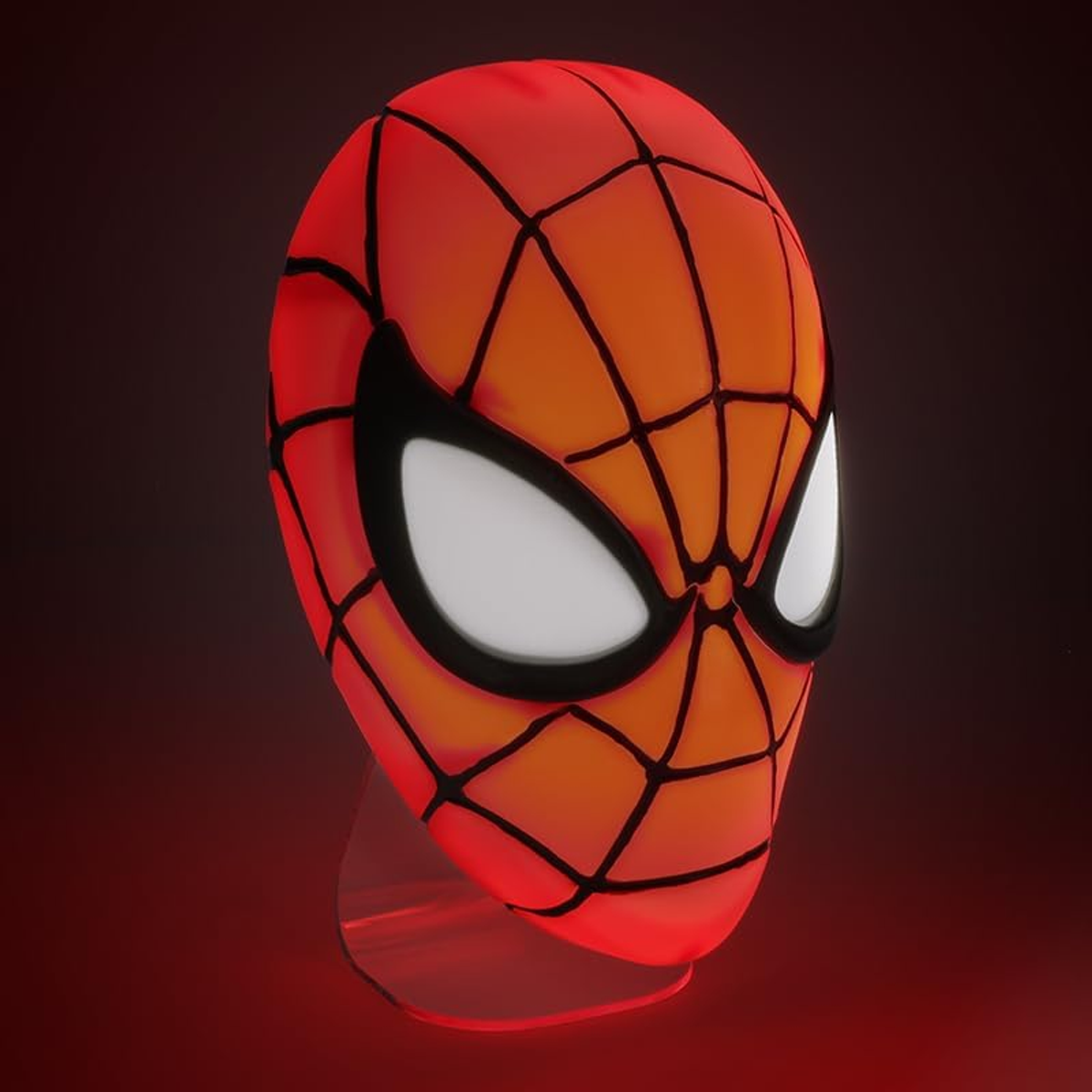Maska Spider-Mana na stojaku ekspozycyjnym, oświetlona czerwonym światłem.