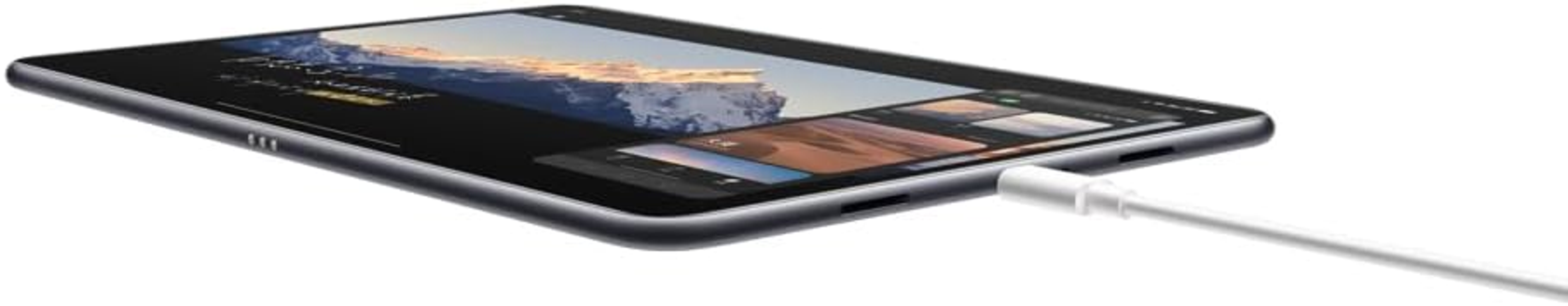 Tablet con cavo di ricarica bianco collegato. Lo schermo mostra un'immagine. Vista angolata. Sfondo bianco.