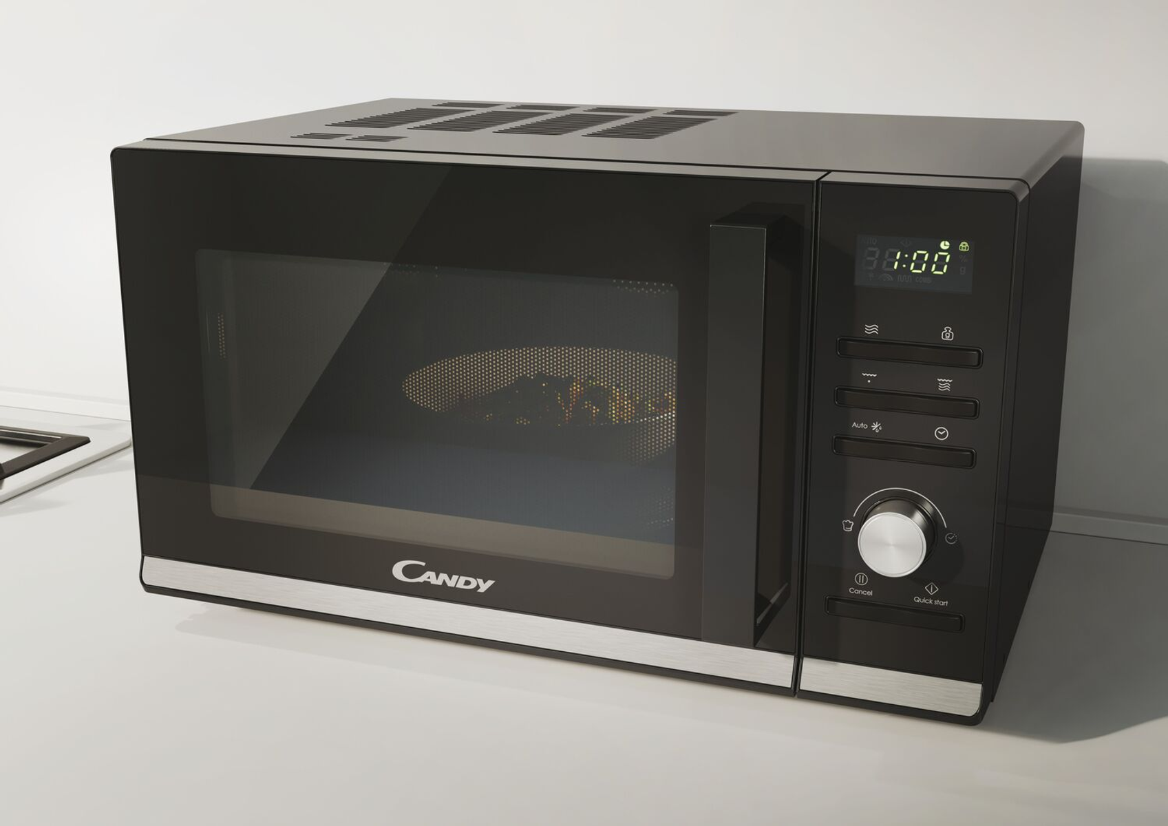 Czarna kuchenka mikrofalowa na białym blacie. Wyświetlacz pokazuje godzinę i logo Candy.