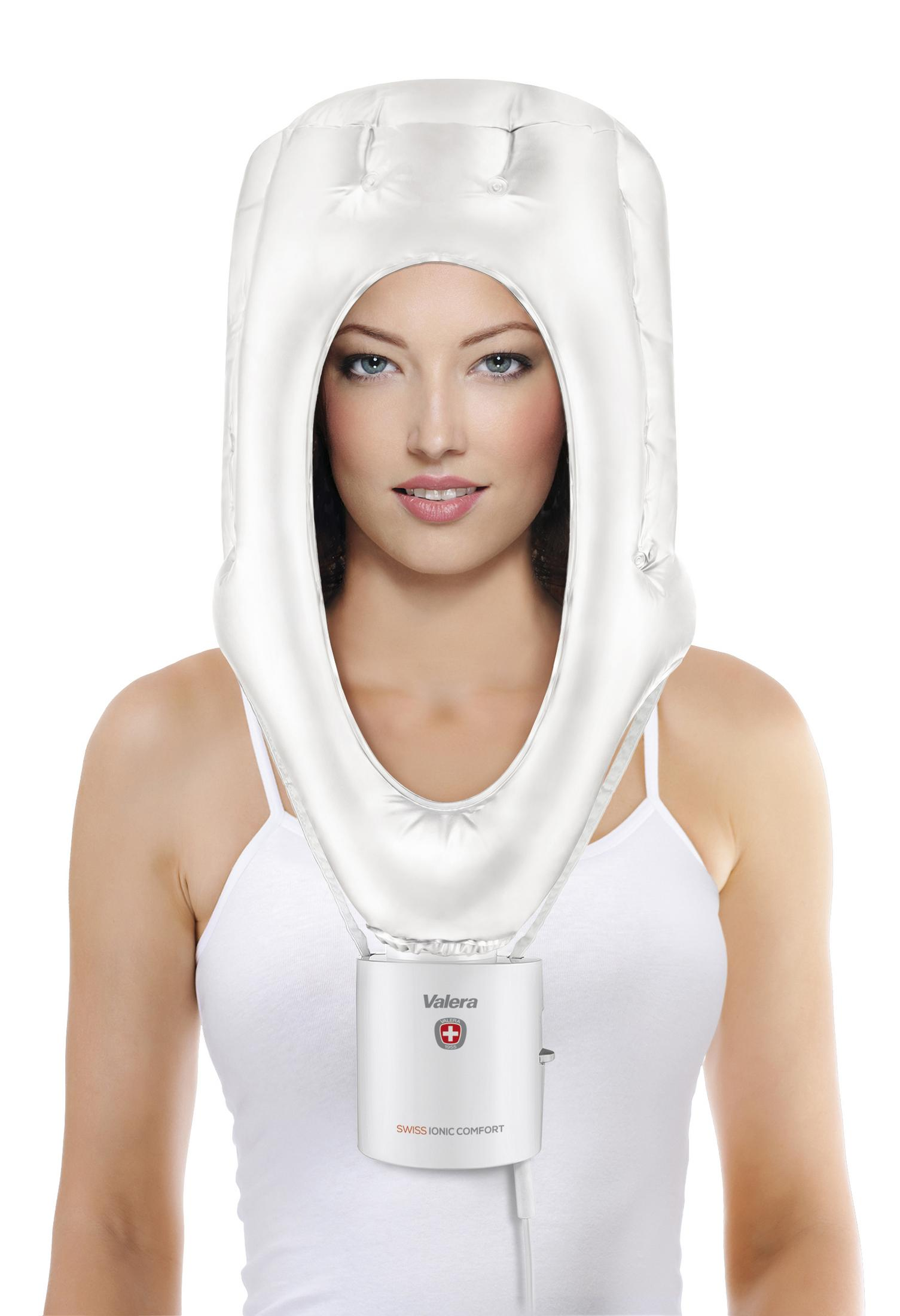 Kobieta nosząca biały kaptur do parowania włosów, patrząca w kamerę.