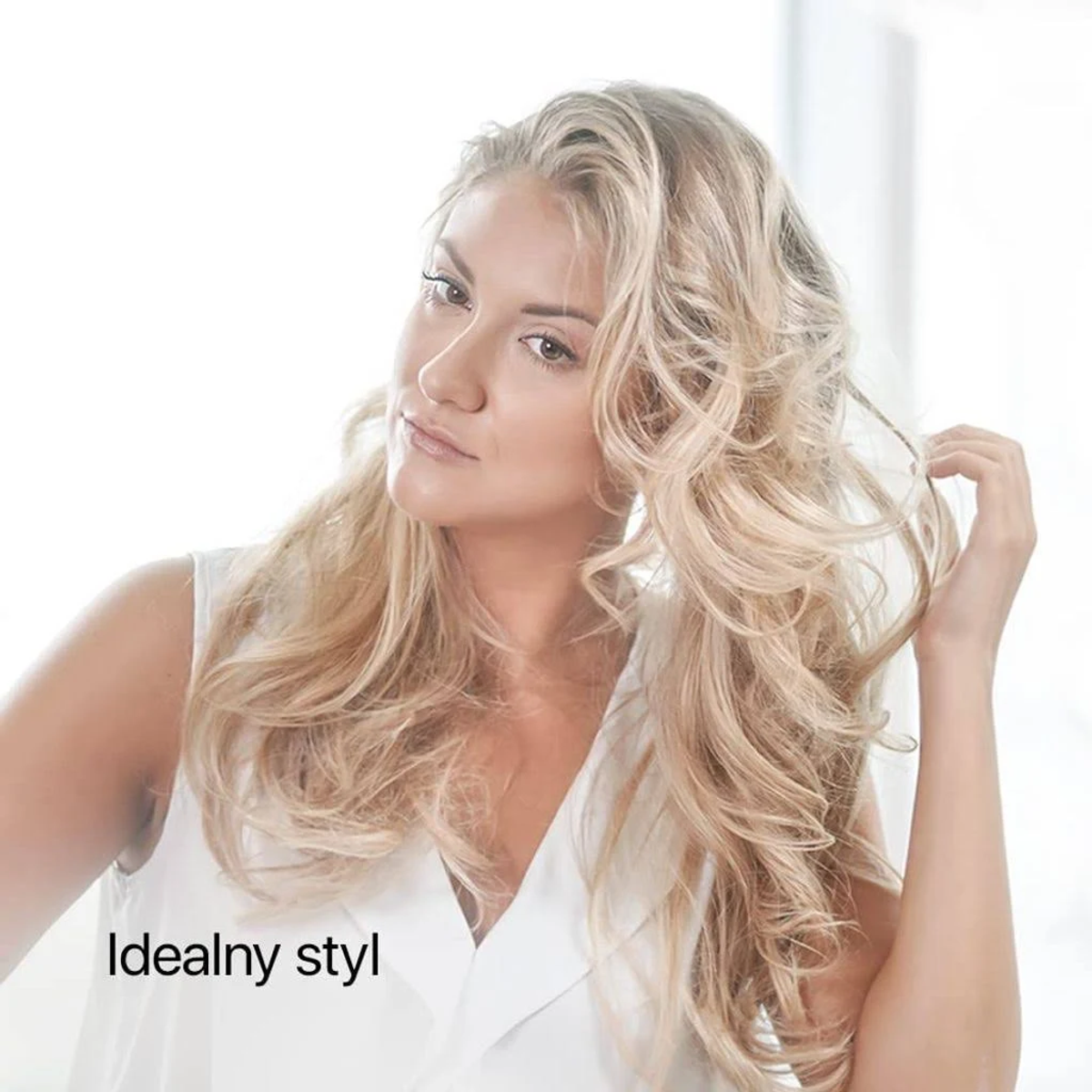 Blondynka z długimi, falowanymi włosami patrząca w kamerę. Tekst mówi 'Idealny styl'.