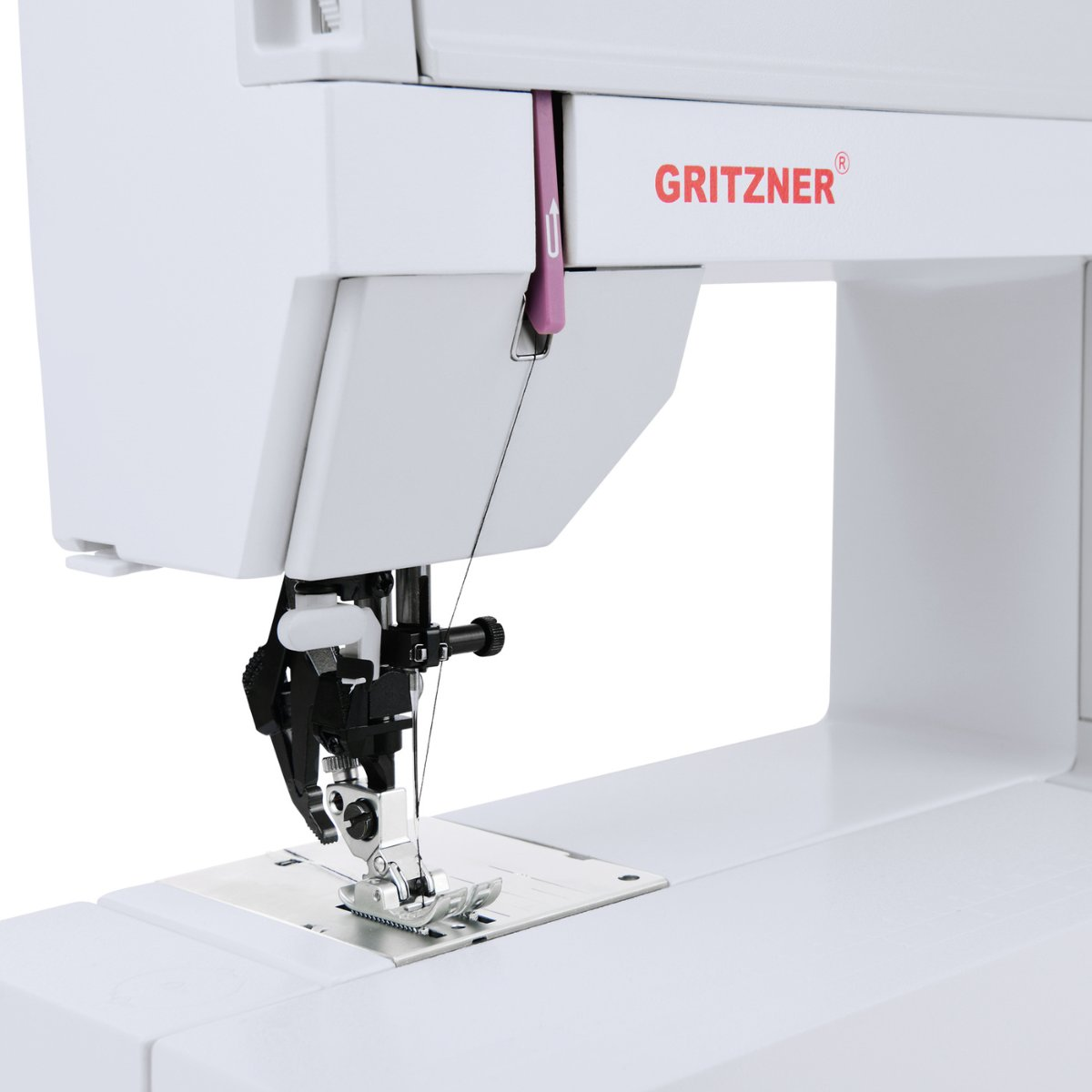 Eine weiße Nähmaschine mit der Marke 'GRITZNER'. Die Nadel ist unten, schwarzer Faden sichtbar, bereit zum Nähen.
