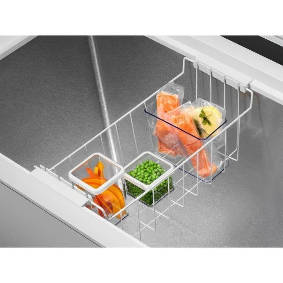 Interno del congelatore con contenitori di cibo, tra cui verdure e pesce.