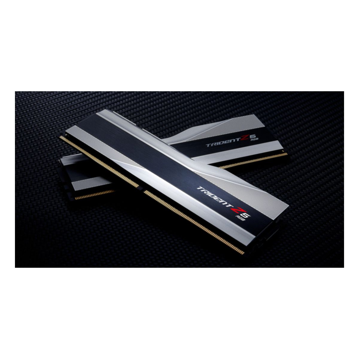 Dwa srebrne moduły RAM z czarnymi paskami i białymi etykietami. Umieszczone są na czarnej powierzchni.