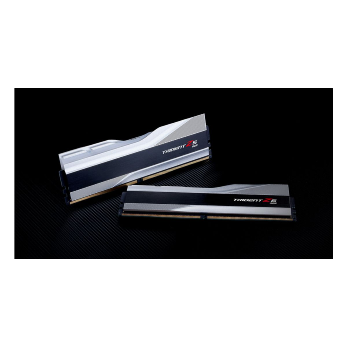 Dwa moduły pamięci RAM do komputera, srebrne i czarne, na teksturowanej powierzchni.