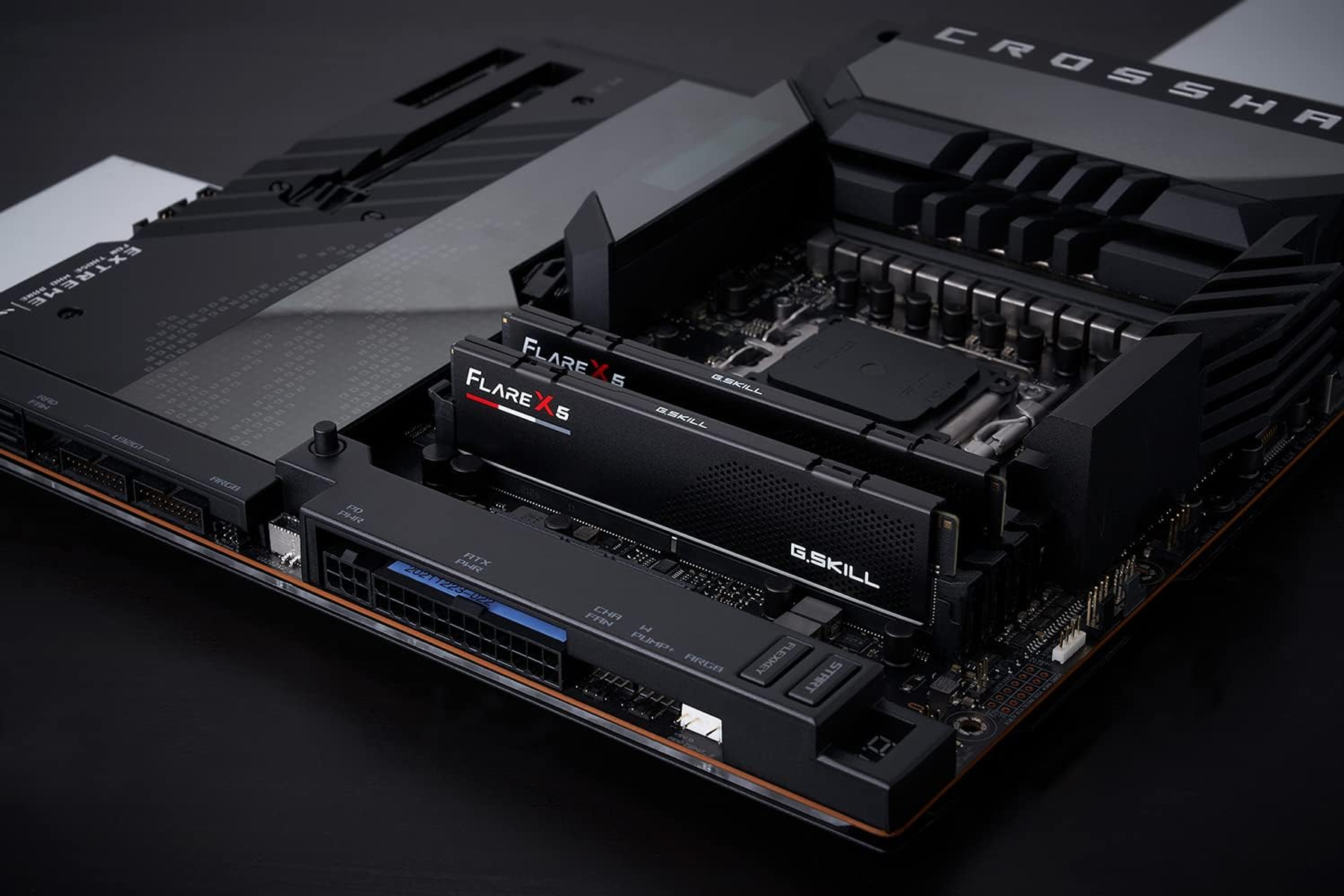 Zbliżenie płyty głównej komputera z zainstalowaną pamięcią RAM. Kolory czarny i szary.