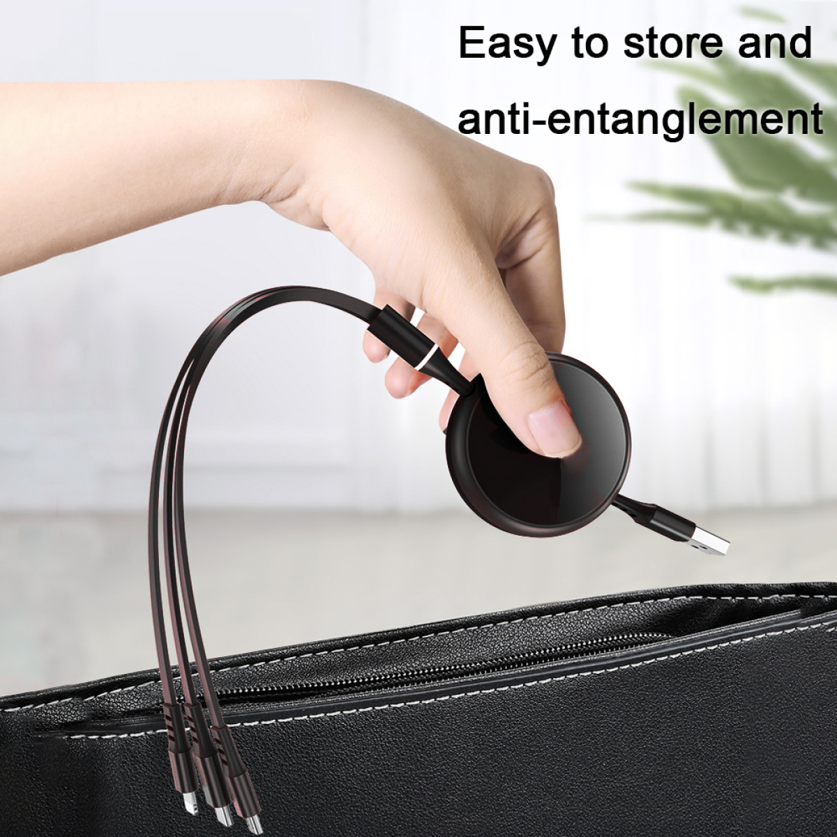 Ein schwarzes USB-Kabel mit mehreren Anschlüssen und eine Hand, die es hält. Das Kabel ist in einer dunklen Handtasche.