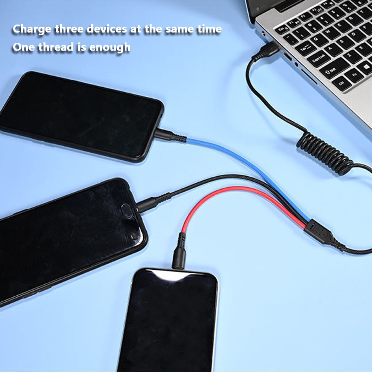 Drei Telefone werden über blaue und rote Kabel von einem Laptop aufgeladen.