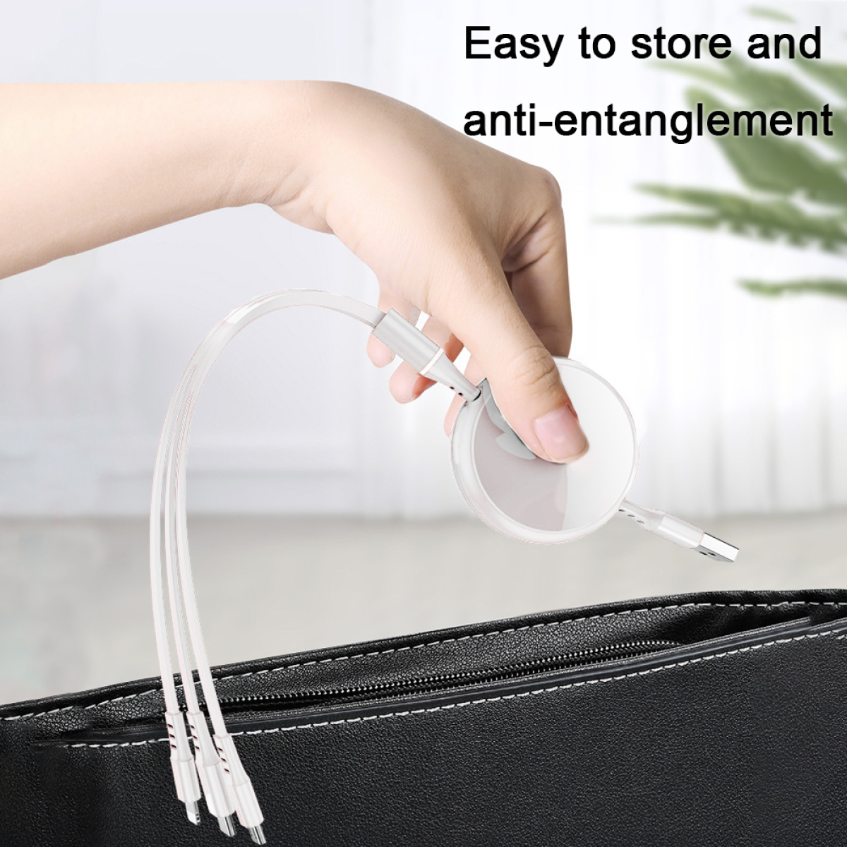 Eine Hand hält ein einziehbares Ladekabel mit mehreren Anschlüssen über einer schwarzen Handtasche.