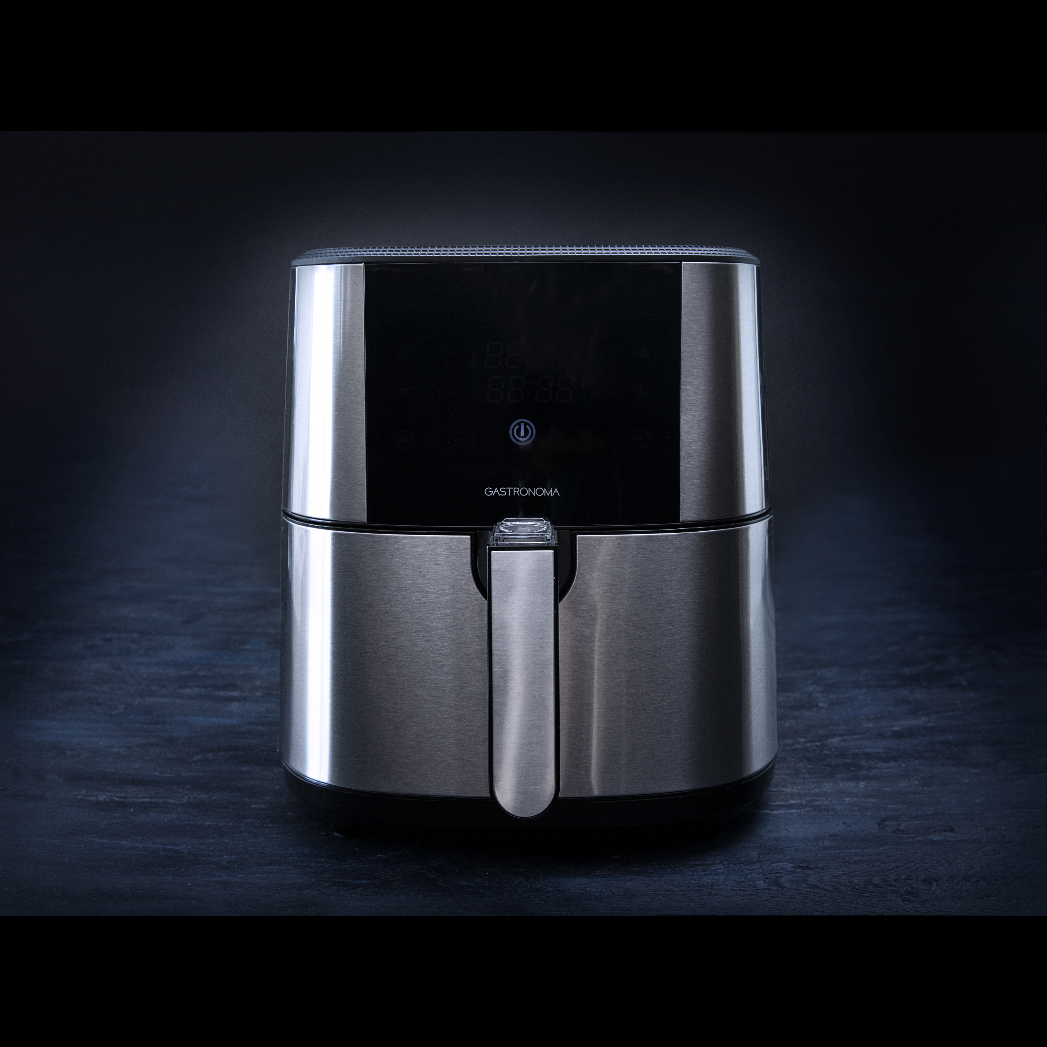 Frytownica beztłuszczowa na ciemnej powierzchni. Srebrna, z cyfrowym wyświetlaczem i uchwytem.