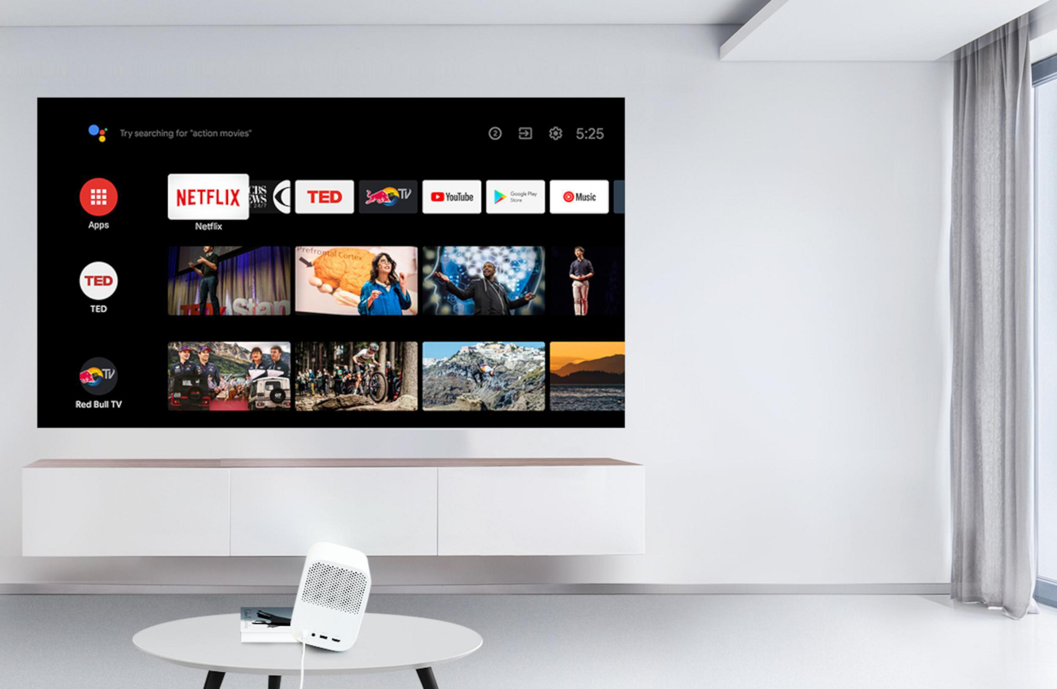 Salon z telewizorem wyświetlającym aplikacje usług strumieniowych. Biały głośnik na stole.