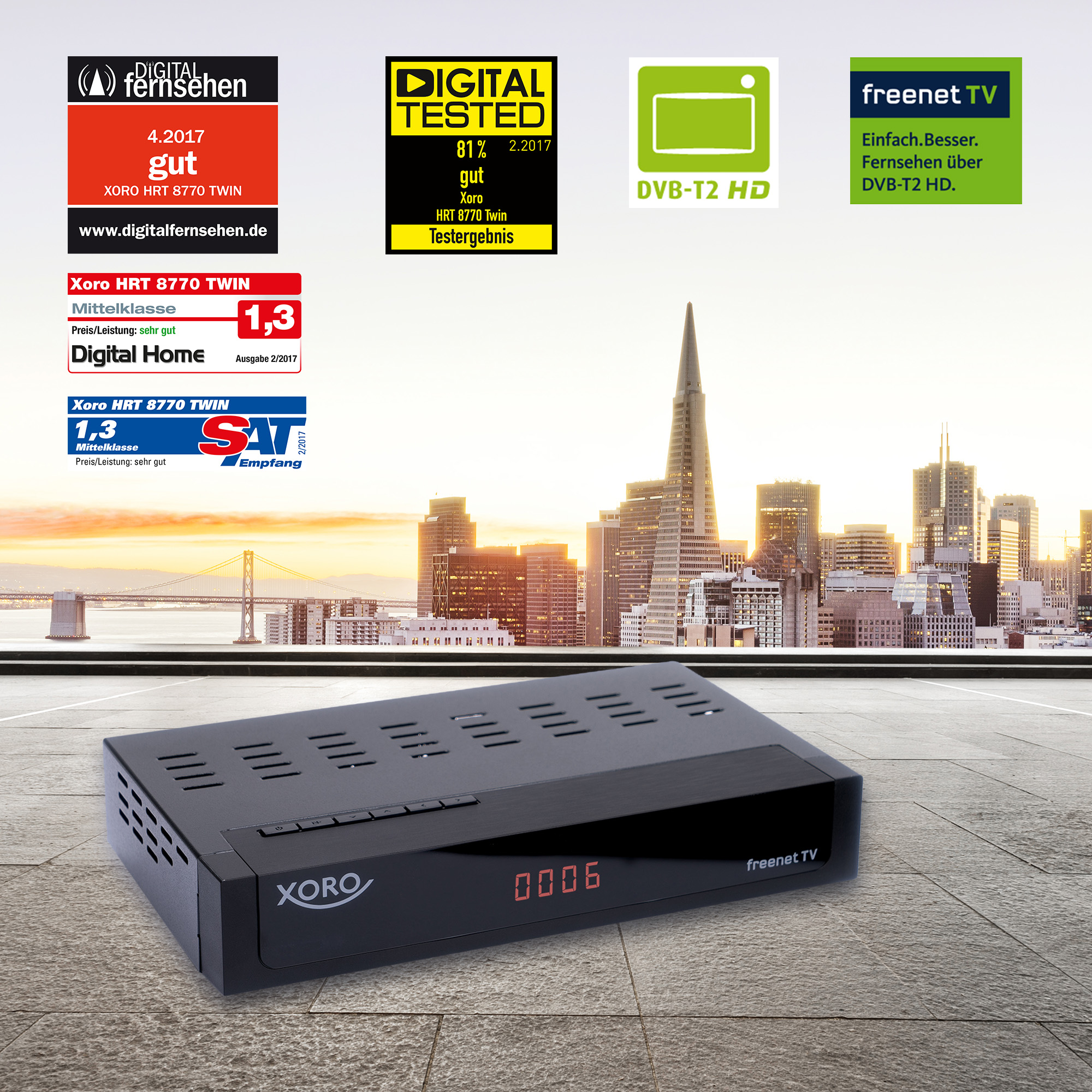 Schwarzer freent TV-Receiver mit Logos. Eine Stadtlandschaft im Hintergrund. Digital Home, Digital Tested.
