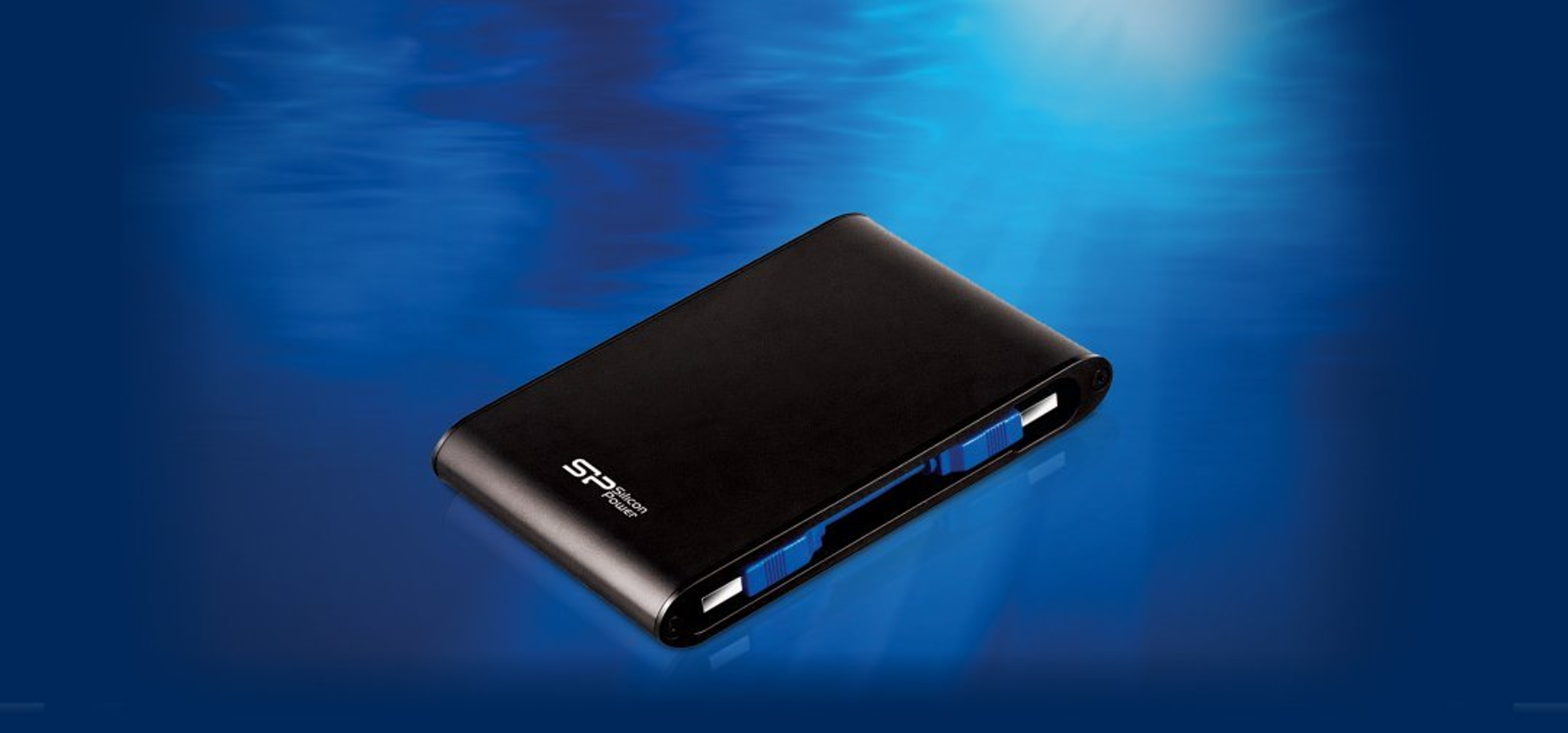 Un disco rigido esterno nero su sfondo blu con riflessi simili all'acqua.