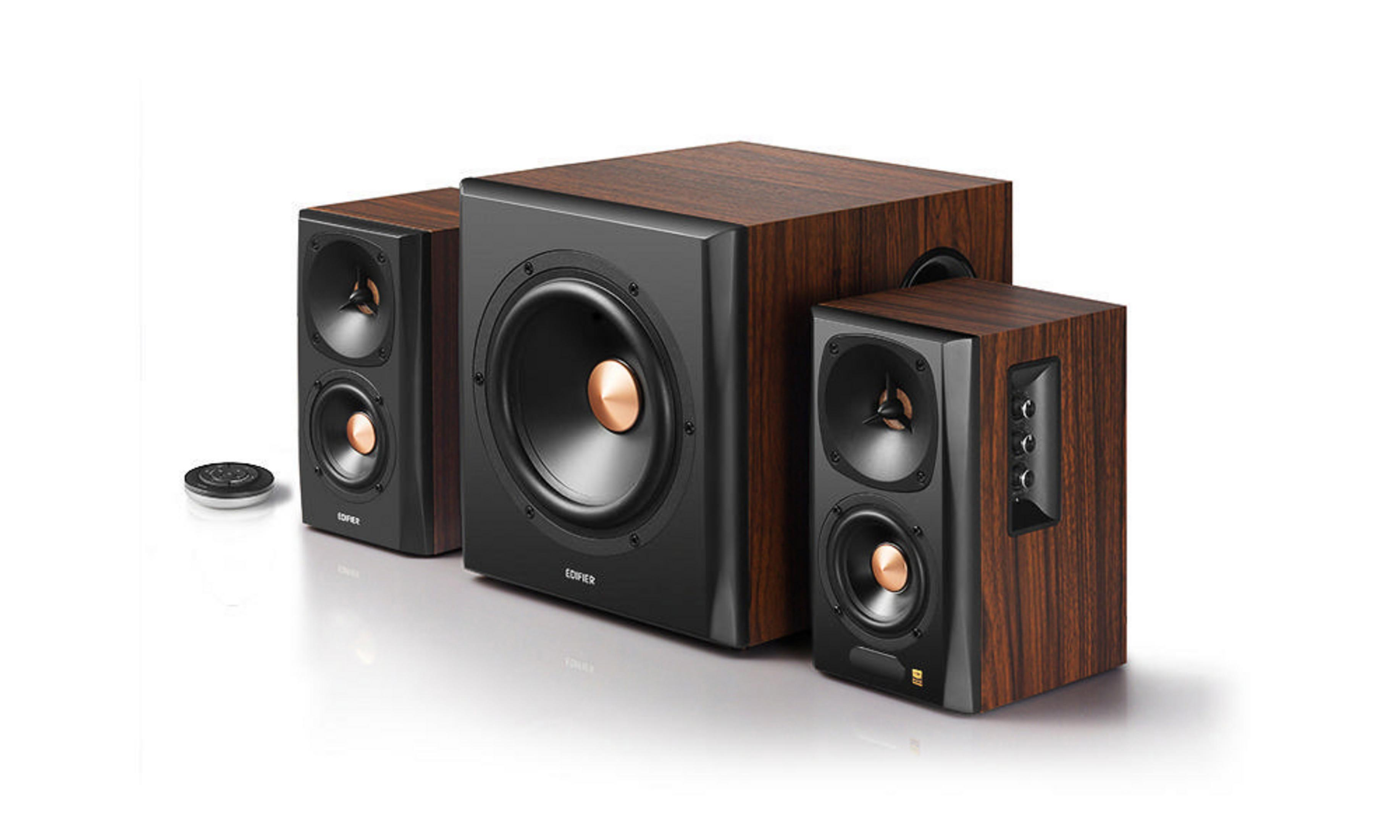 Zestaw głośników z subwooferem i dwoma głośnikami satelitarnymi. Mają wykończenie z usłojeniem drewna ze złotymi akcentami.