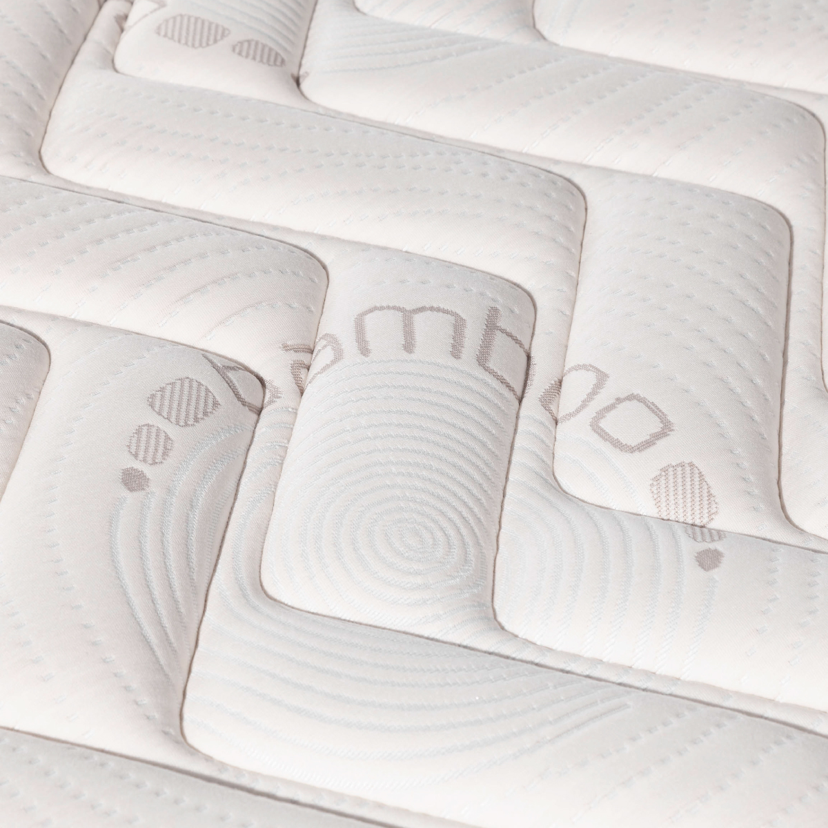 Primer plano de un colchón blanco con patrón y el logo 'bambú'.