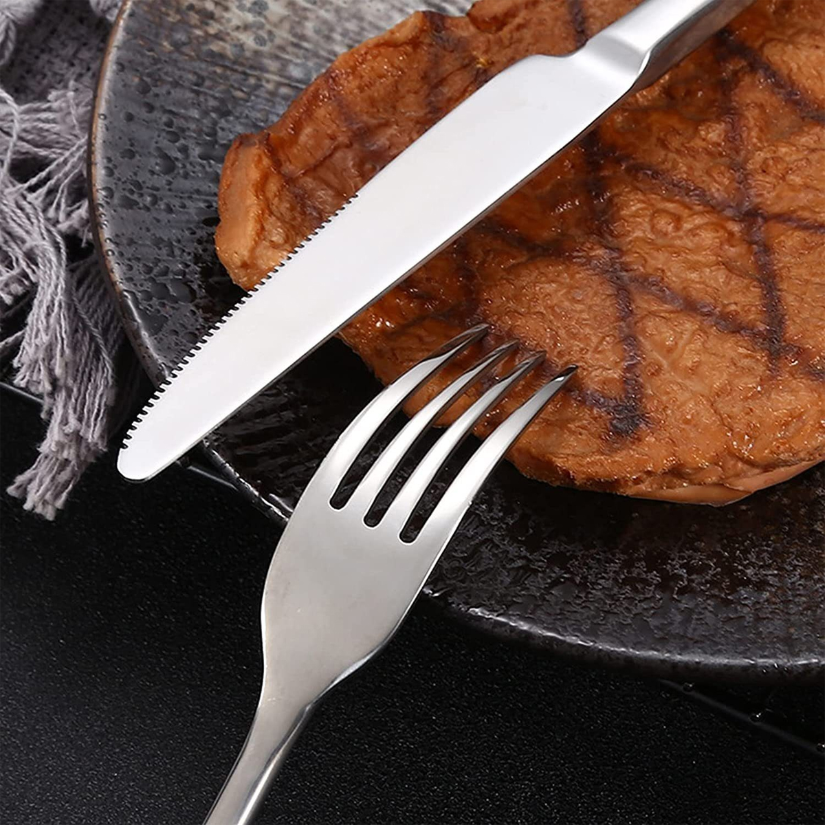 Steak auf einem Teller mit Messer und Gabel, Nahaufnahme.
