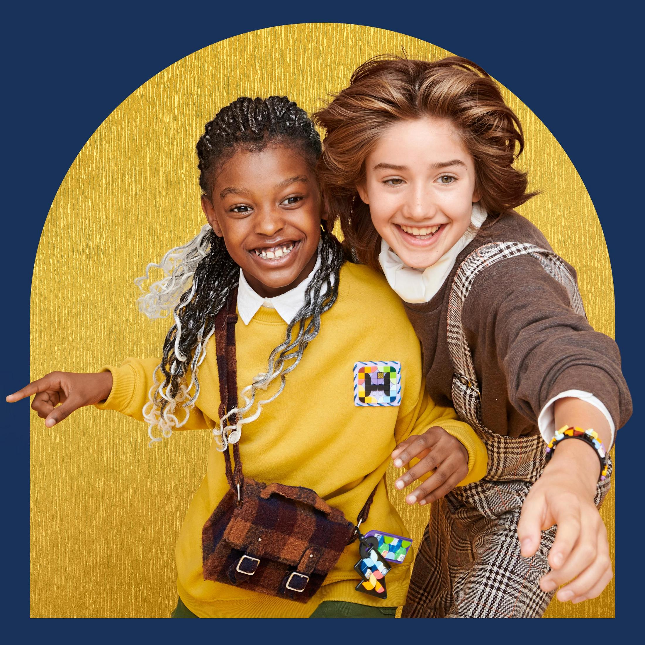 Dwoje uśmiechniętych dzieci z kolorowymi akcesoriami, pozujących razem.