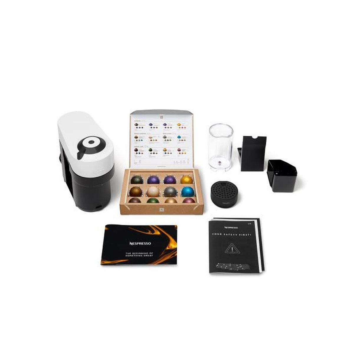 Macchina da caffè con accessori, tra cui capsule, tazze e manuali.