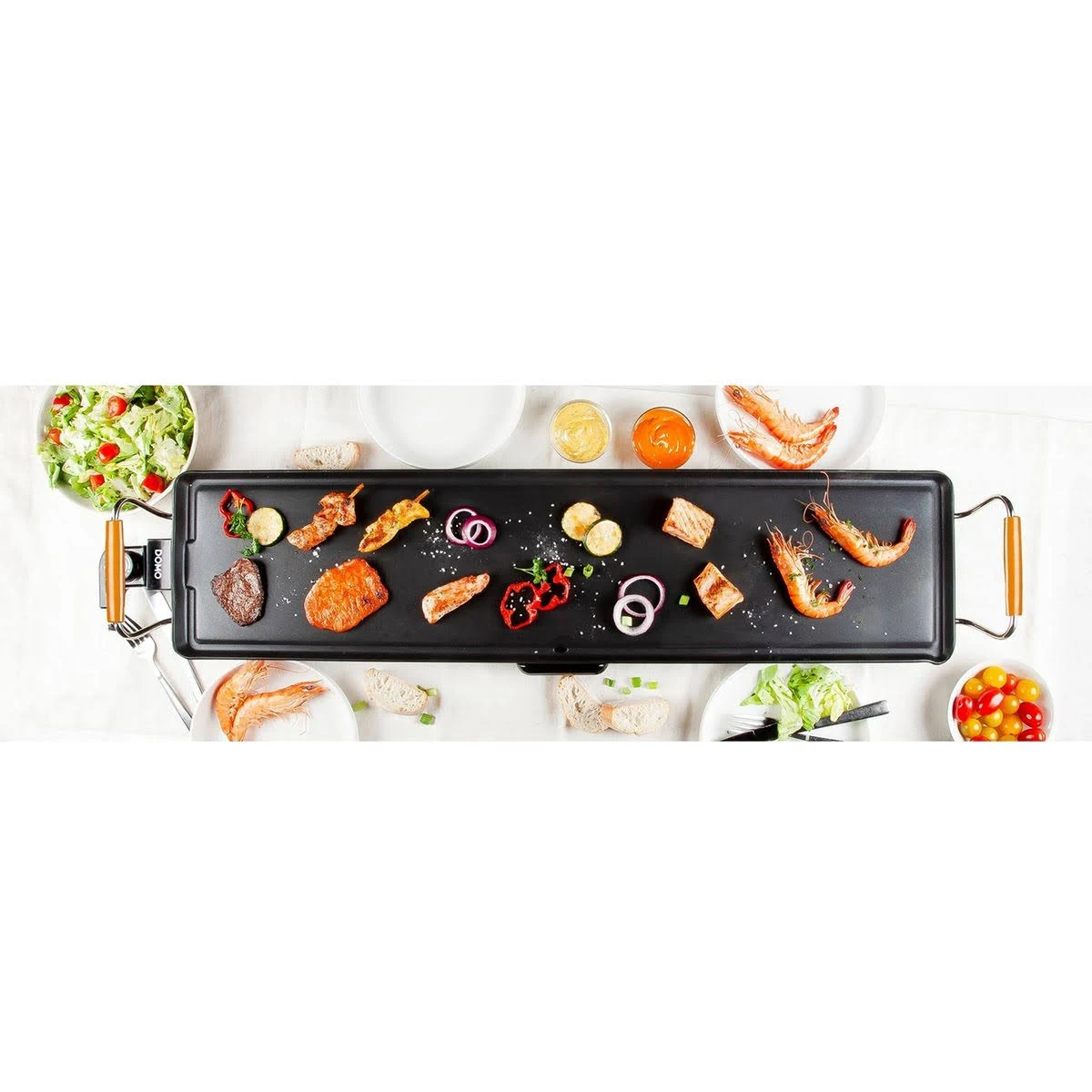 Parrilla rectangular negra con comida. Incluye carne, verduras, camarones, salsas y ensalada. Fondo blanco.