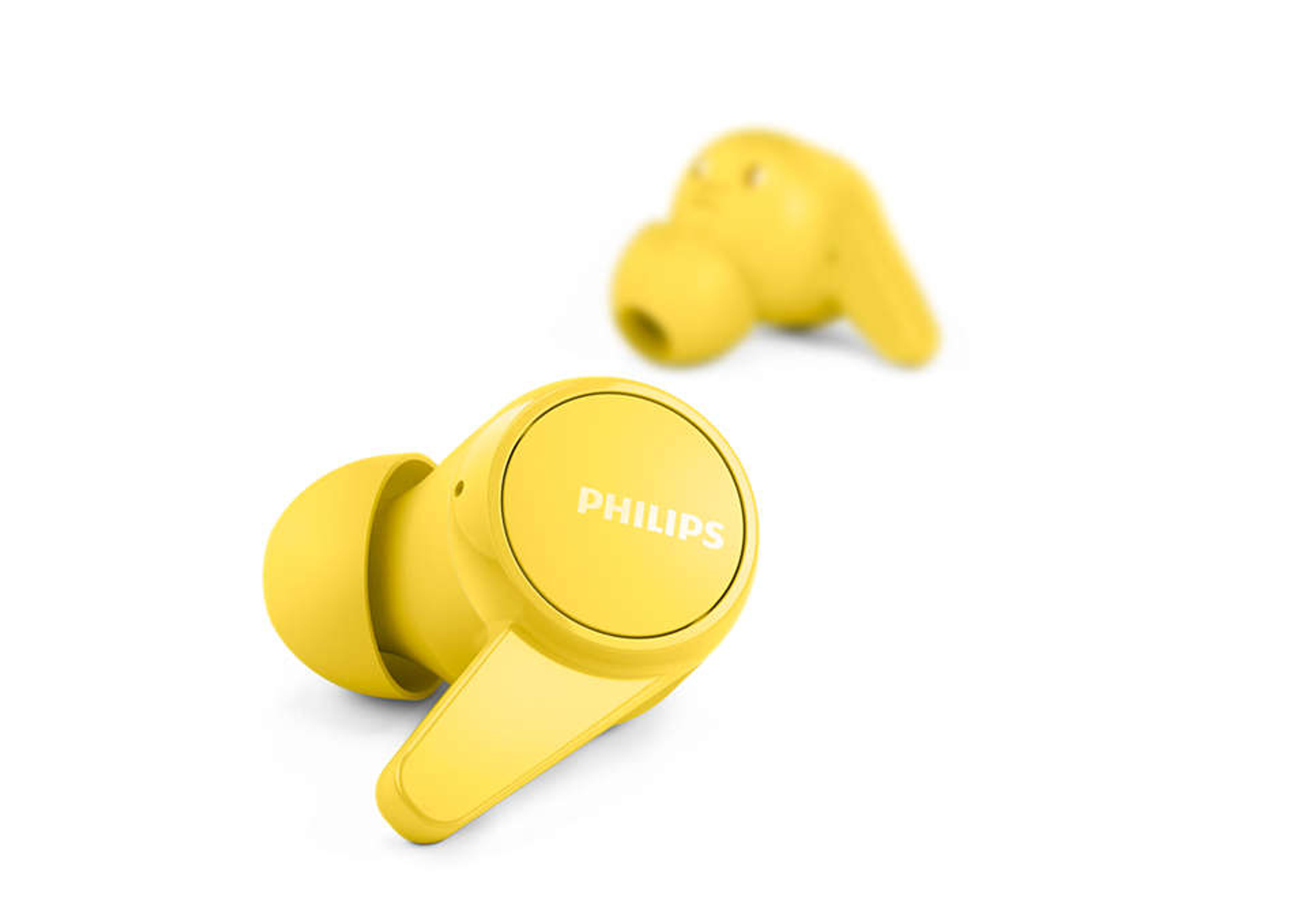 İki sarı Philips kablosuz kulaklık beyaz bir yüzeyde duruyor. Bir kulaklık odaklanmış, diğeri bulanık.
