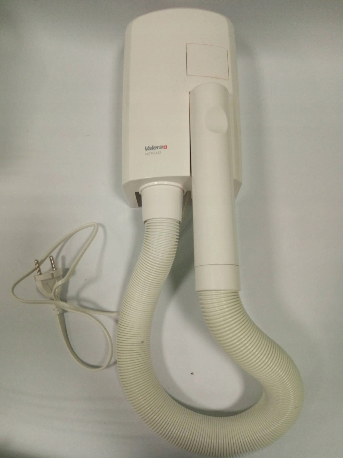 Biała suszarka do włosów Valera Hotel zamontowana na ścianie z elastycznym wężem.