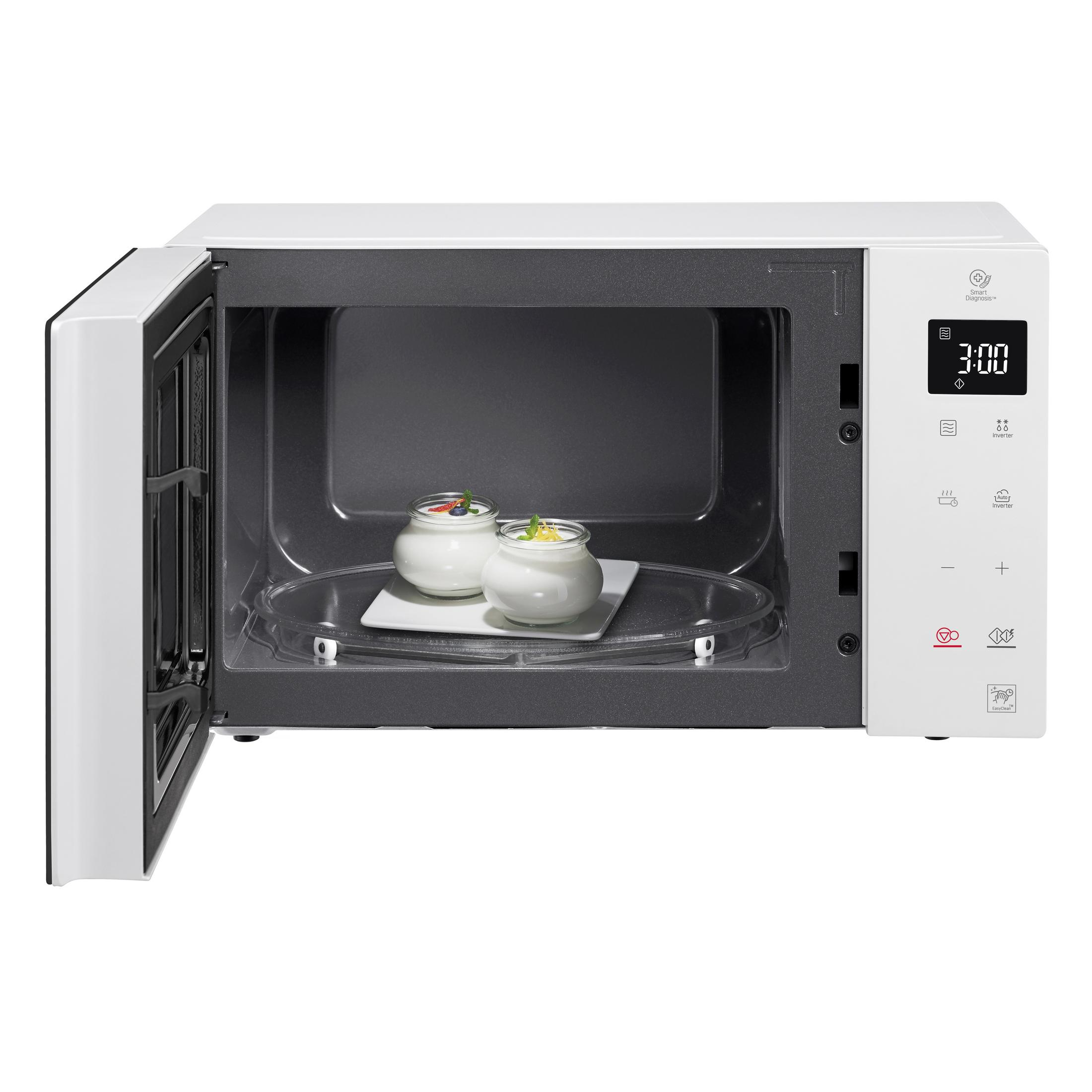 Micro-ondes blanc avec porte ouverte. Deux plats à l'intérieur. Fond blanc.