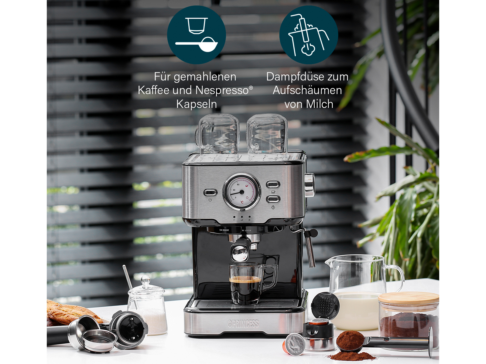 Eine Espresso-Maschine aus Edelstahl und Schwarz mit Zubehör und einer Tasse.