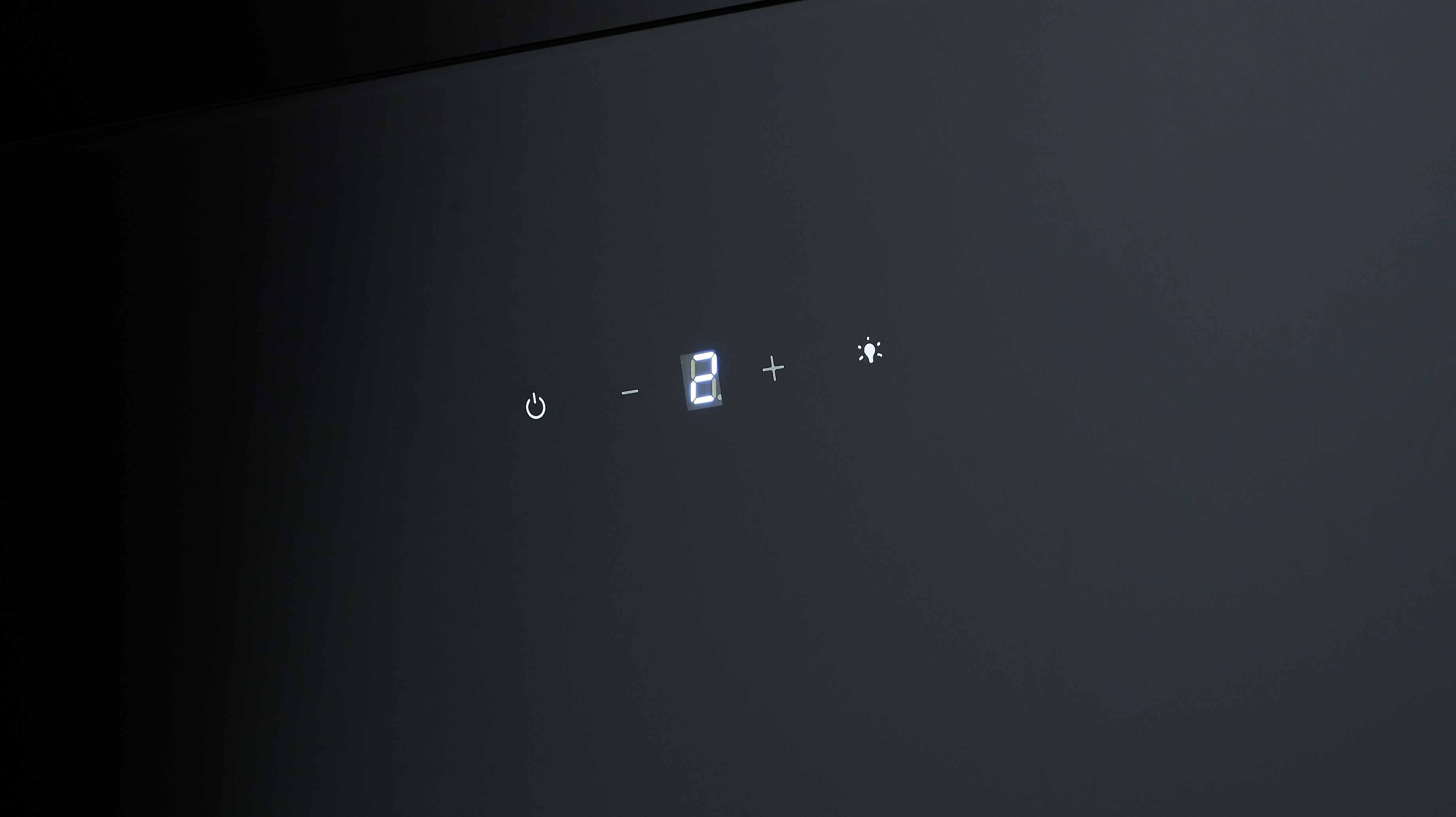 Dispositivo nero con piccolo display che mostra numeri e un simbolo di luce.