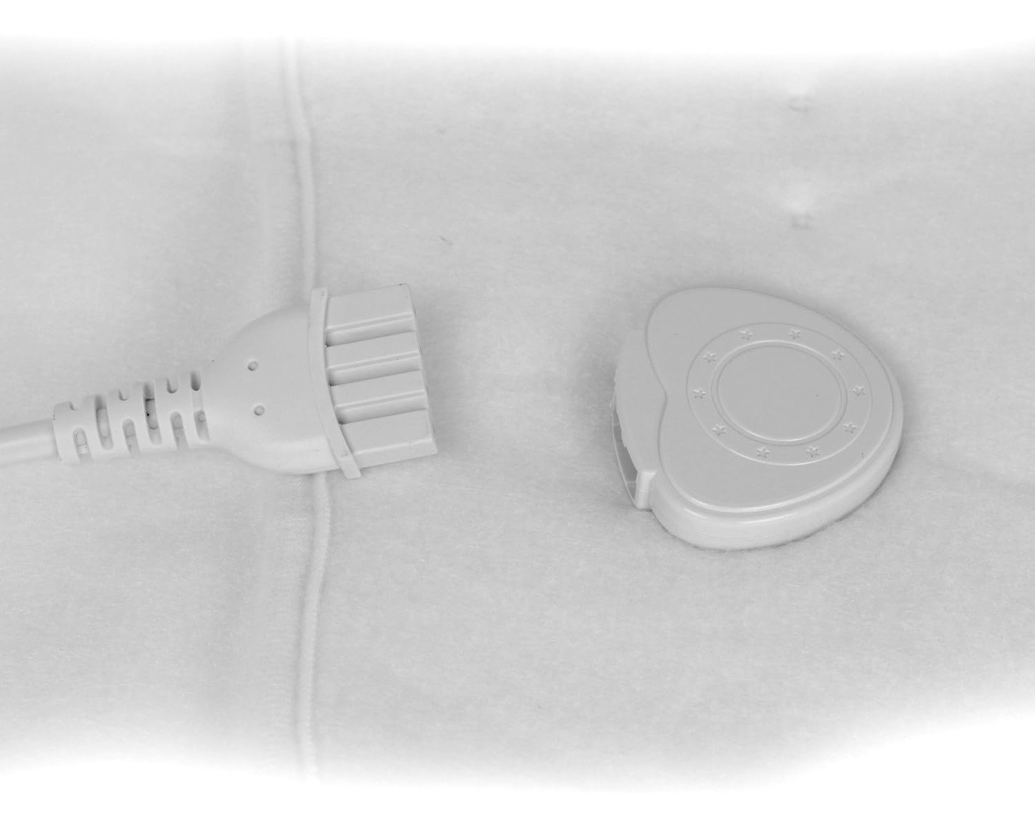 Nahaufnahme eines weißen Netzkabels mit Stecker und separatem Bedienfeld.
