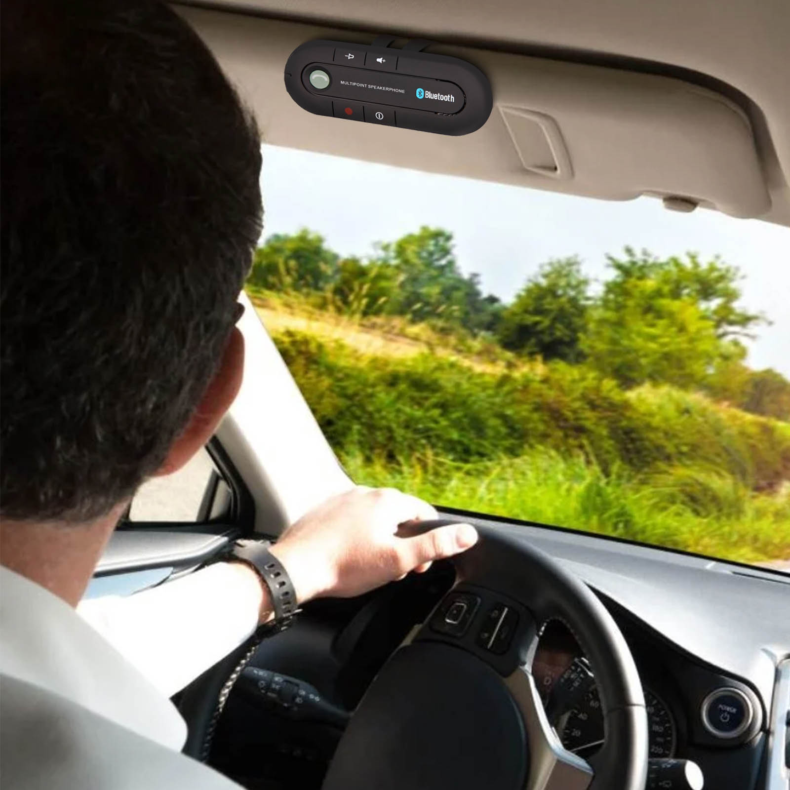 Un uomo che guida un'auto con un vivavoce Bluetooth attaccato alla visiera.