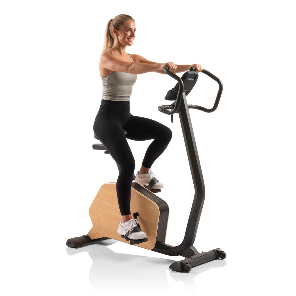 Frau auf Holz-Heimtrainer mit schwarzem Rahmen. Weißer Hintergrund. Fitnessgerät.