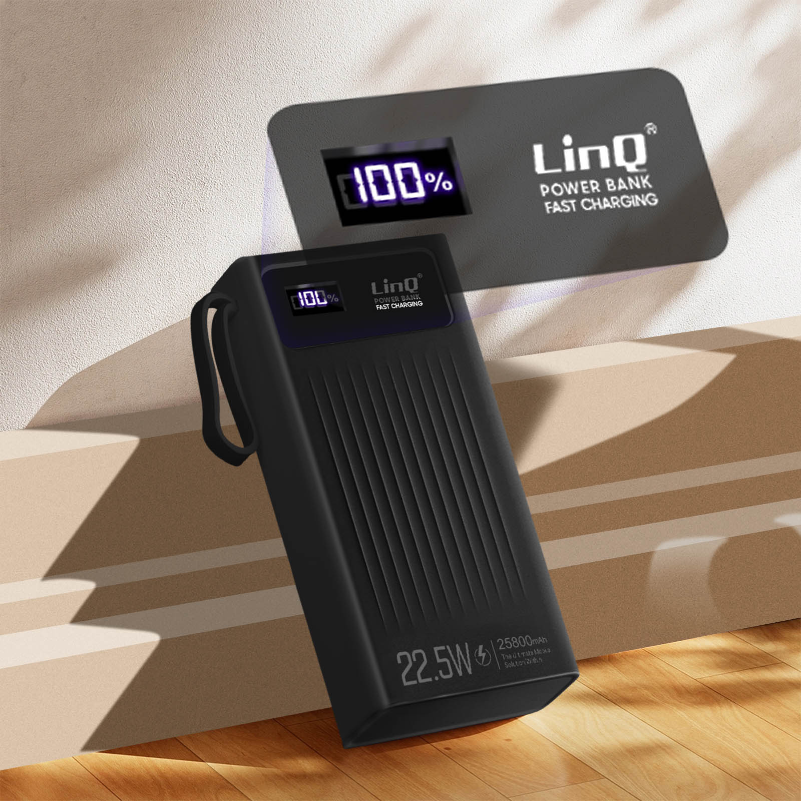 Batterie externe noire avec écran à 100%, à côté d'un mur avec port de charge.